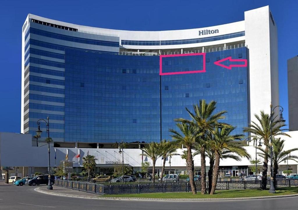 a hilton building with a pink sign on it at Hilton Tanger Penthouse 14 in Tangier