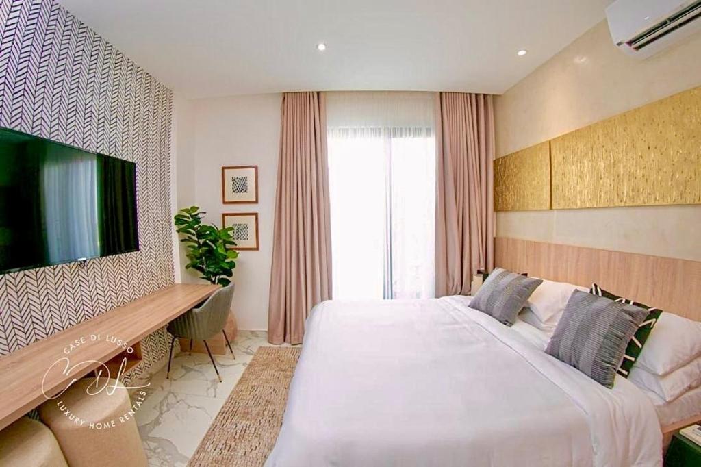 Un dormitorio con una cama grande y un televisor de pantalla plana. en Stylish Spacious Studio with Pool & Fitness Centre, en Accra