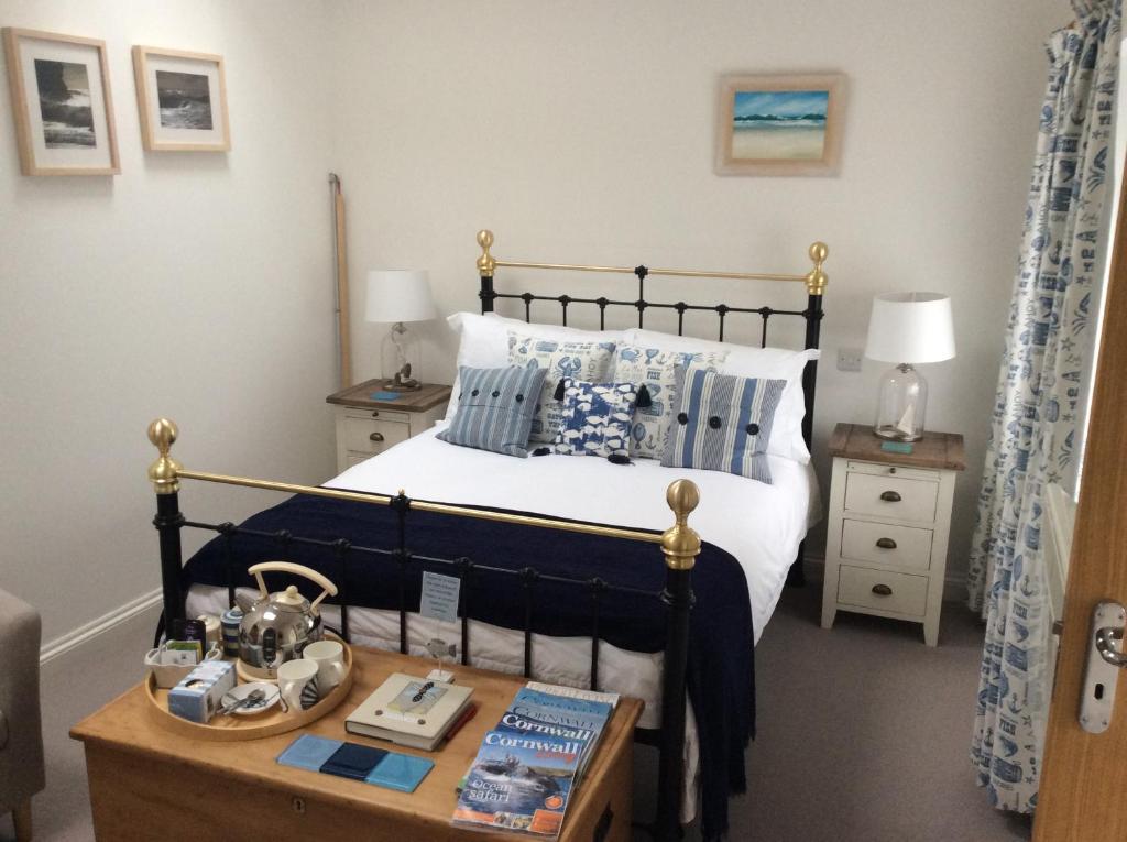a bedroom with a bed and a wooden table at Trenance House in Helston