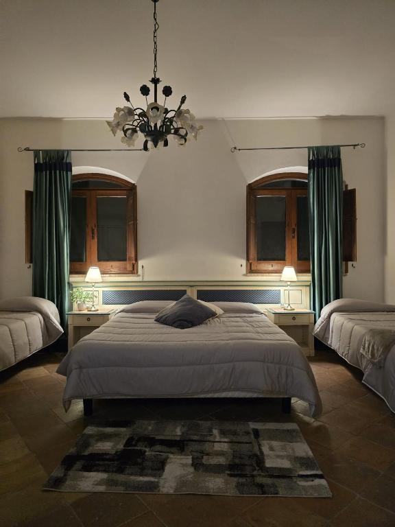 a bedroom with a large bed and a chandelier at Tenuta Oliva in Fisciano