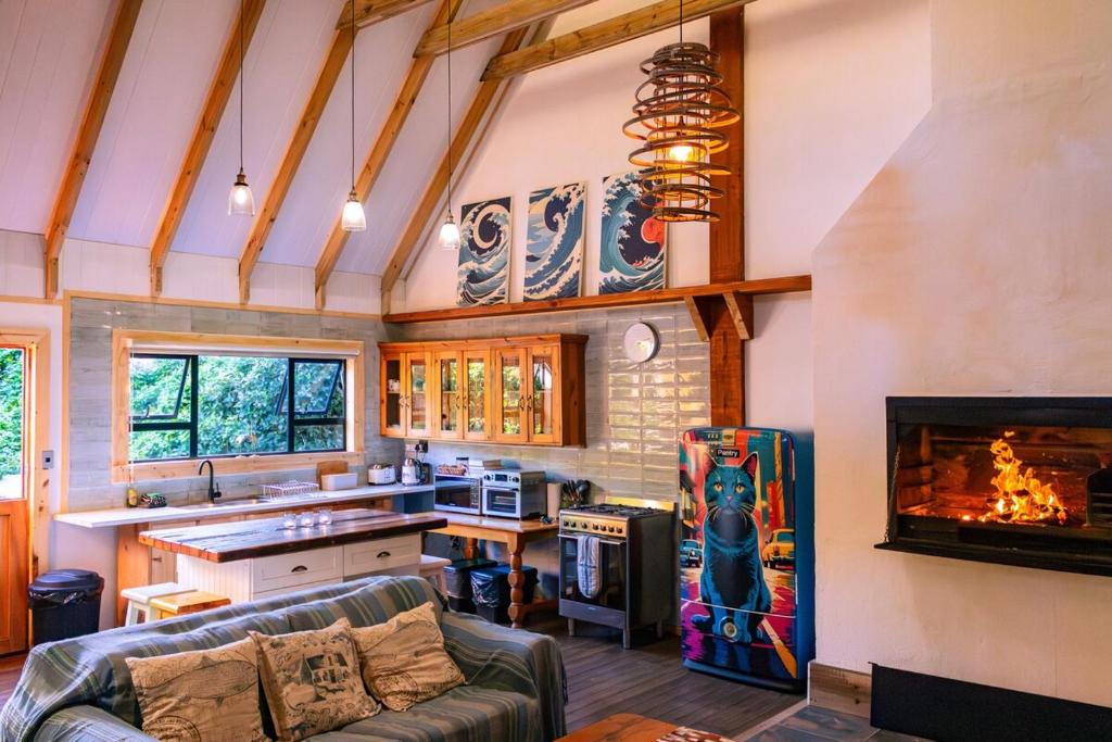 a living room with a couch and a fireplace at Magical Cabin in the Woods in Kleinbaai
