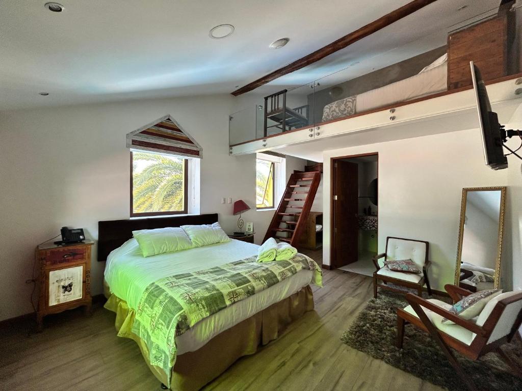 - une chambre avec un grand lit et une échelle dans l'établissement Villa Ana María Cuenca-Hotel, à Chaullamba