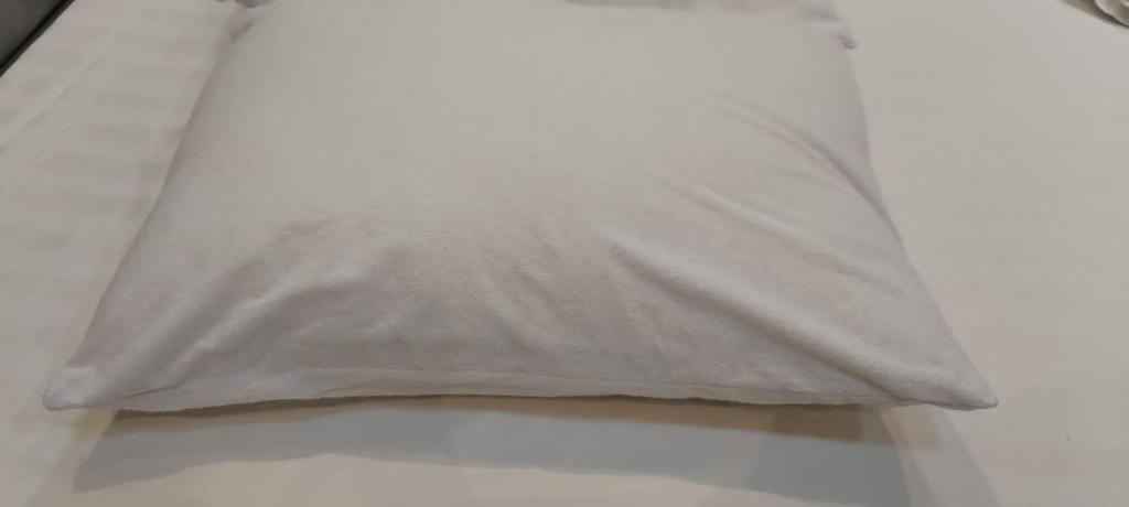 ein weißes Kissen auf dem Bett in der Unterkunft Adeem Serviced Apartments in Al Hofuf