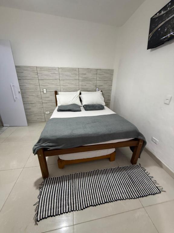 een bed in een witte kamer met bij SUITE Yeshua in Paraty