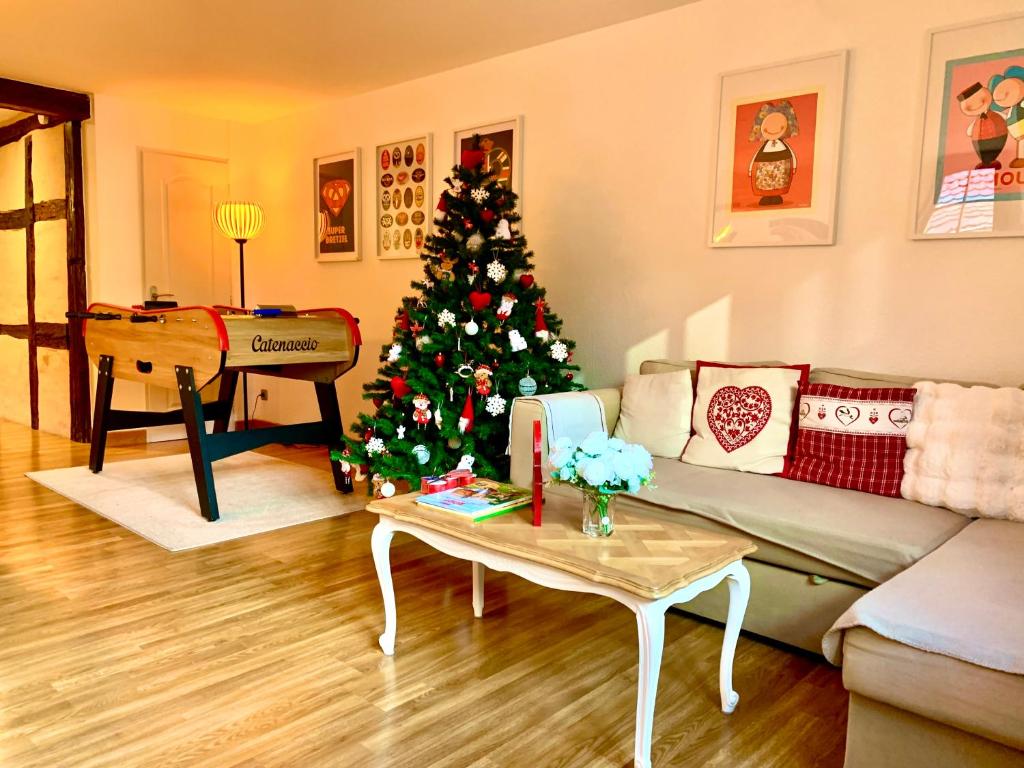 ein Wohnzimmer mit einem Weihnachtsbaum und einer Couch in der Unterkunft Gîte " le Schmoutzi" Duplex centre historique Riquewihr in Riquewihr
