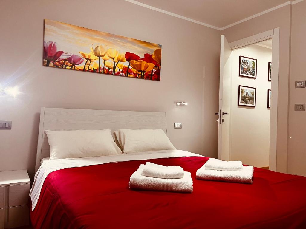 Un dormitorio con una cama roja con una pintura en la pared en La Rose du Prevot, en Fenis