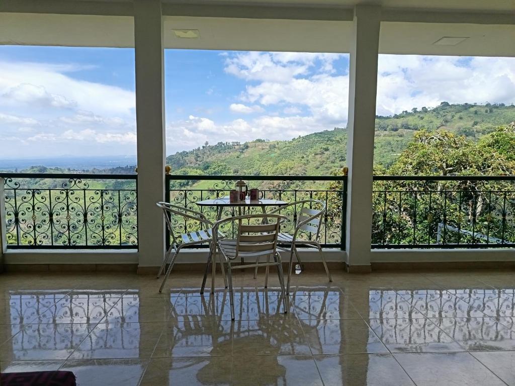 Ein Tisch und Stühle auf einem Balkon mit Aussicht in der Unterkunft Panorama Café Hostel in Buenavista
