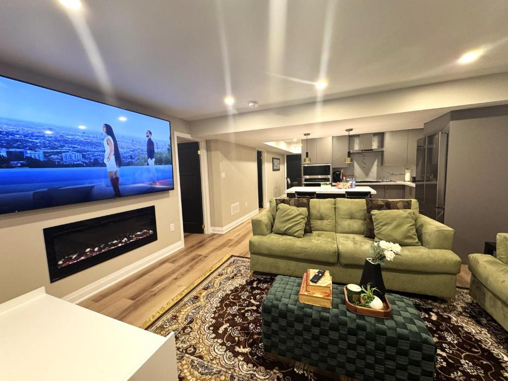 a living room with a couch and a flat screen tv at Luxury 2-Bedroom Designer Suite Richmond Hill Lake Wilcox in Richmond Hill
