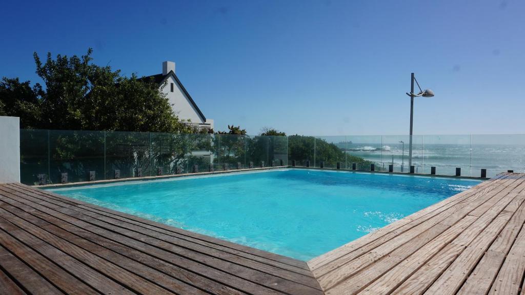 a large blue swimming pool on top of a house at Seaside apartment - Big Bay beach in Cape Town