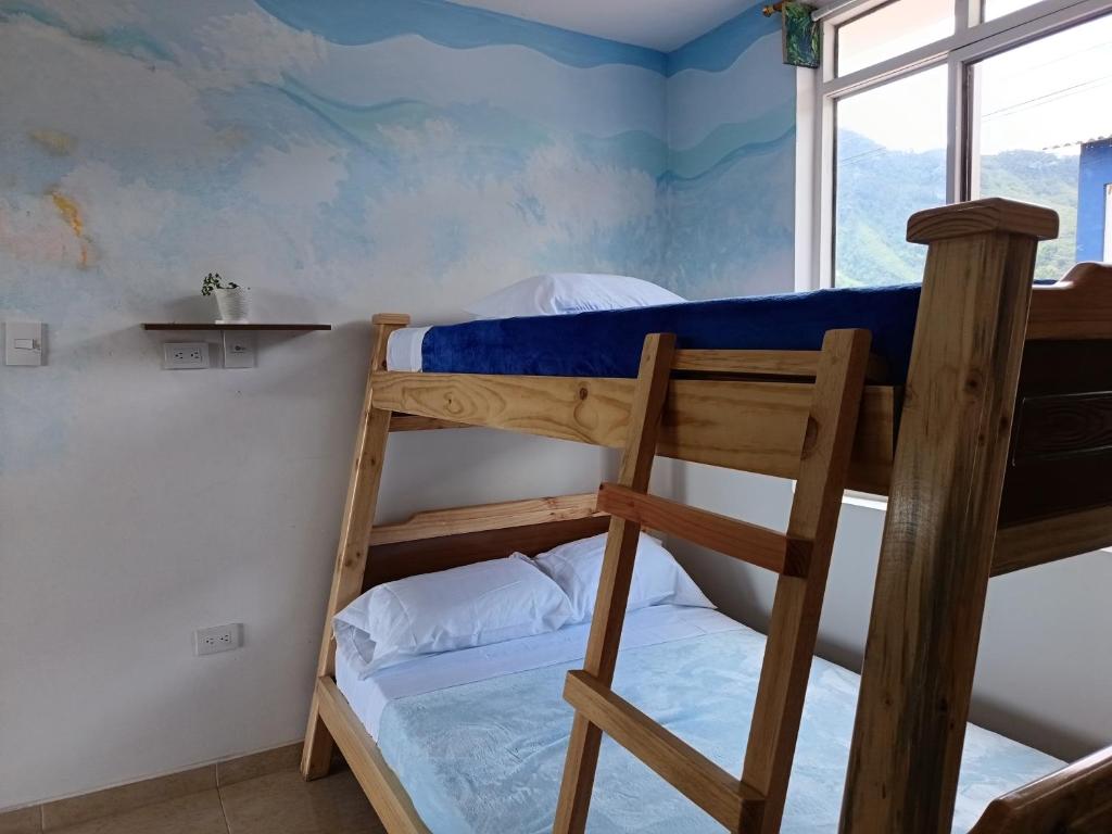 a bedroom with two bunk beds and a window at Panorama Café Hostel in Buenavista