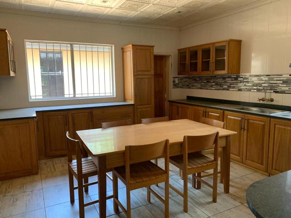 a large kitchen with a wooden table and chairs at Hazel Nest Ezulwini in Ezulwini