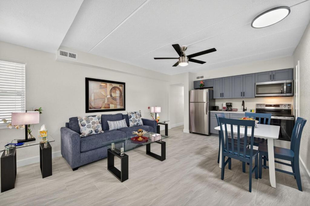 a living room with a blue couch and a kitchen at Sunset Beach Suites Unit 1 in St. Pete Beach