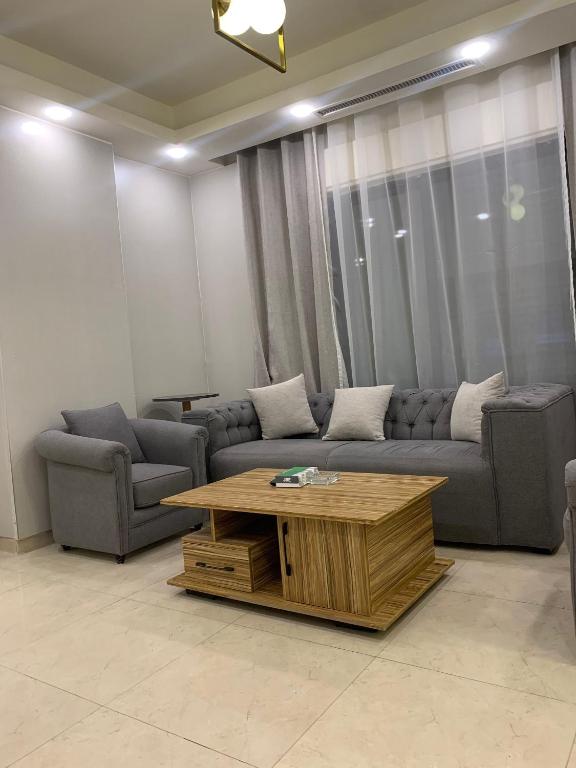 ein Wohnzimmer mit einer Couch und einem Couchtisch in der Unterkunft Luxurious 3 Bedroom Apartment in Heart of Amman in Rujm ash Sharāʼirah