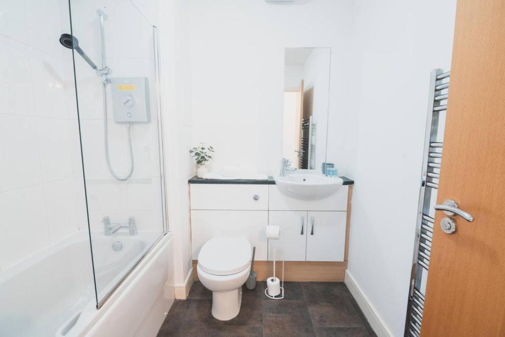 a bathroom with a toilet and a sink and a shower at Top-Floor 2-Bed Near Braehead in Renfrew