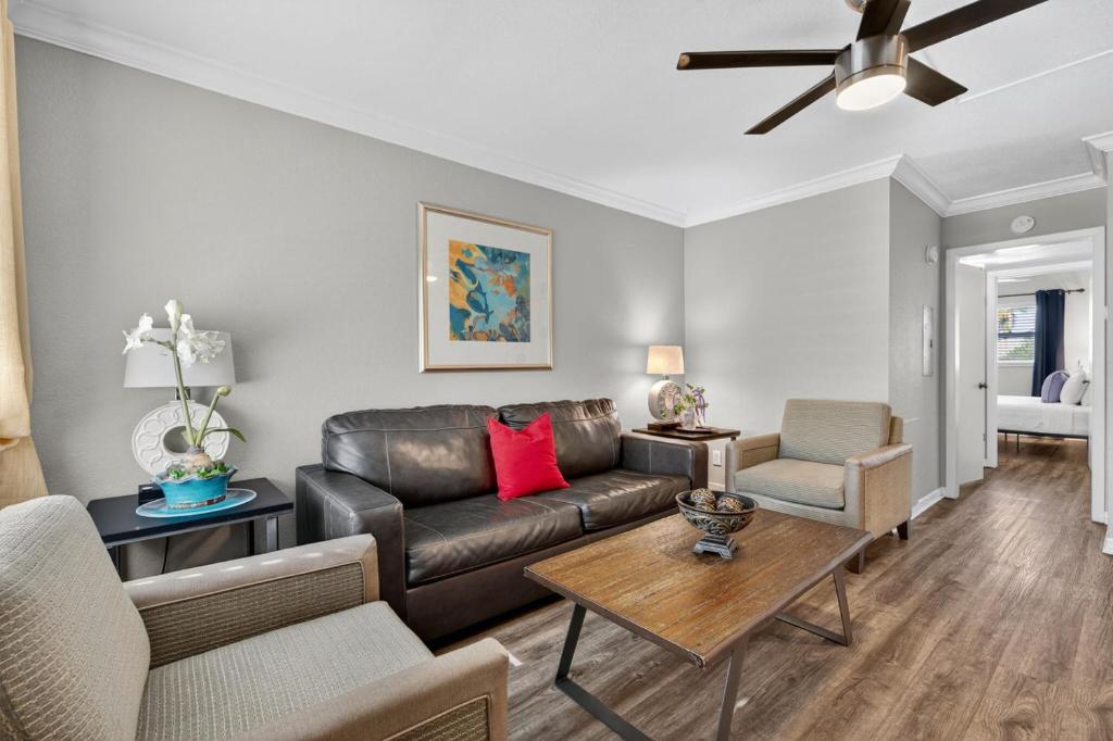 a living room with a leather couch and a table at Sunset Beach Suites Unit 7 in St. Pete Beach