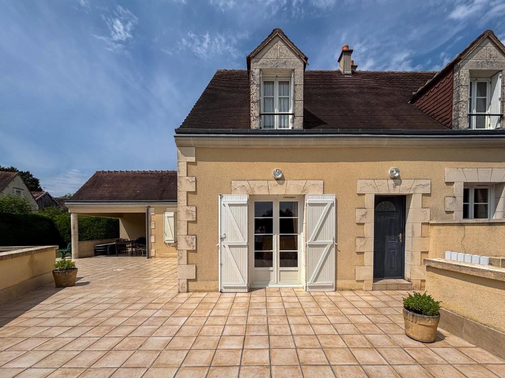 une maison avec des portes blanches et une allée en briques dans l'établissement Maison de charme avec piscine chauffée, proche châteaux de la Loire et Zoo de Beauval - FR-1-591-97, à Villentrois