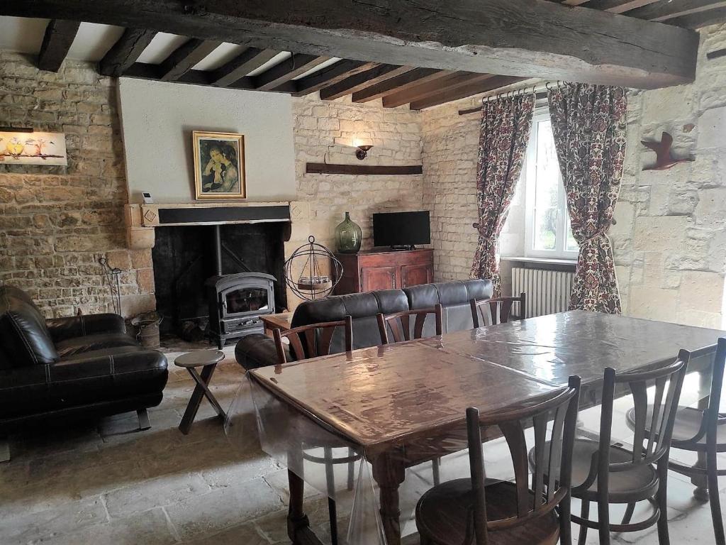 a living room with a table and chairs and a fireplace at Gîte indépendant au bord de la rivière, cadre historique, pêche, animaux bienvenus, parking privé - FR-1-586-22 in Mareuil-sur-Arnon