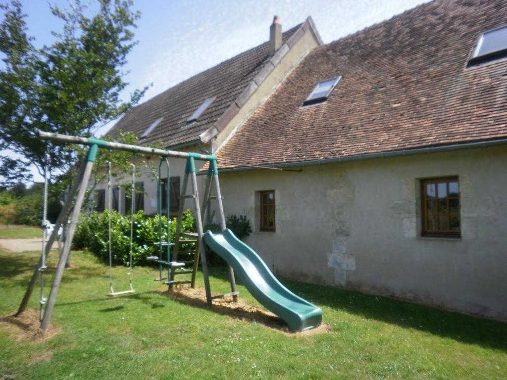 eine Rutsche in einem Hof vor einem Haus in der Unterkunft Gîte familial près de Châteauroux avec jardin, aire de jeux et location de salle, idéal pour 8 pers. - FR-1-591-12 in Arthon