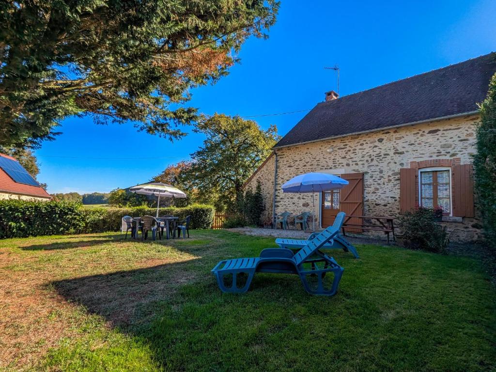 Gîte champêtre avec jardin clos, près du lac d'Eguzon et Gargilesse-Dampierre ! - FR-1-591-127 في Orsennes: ساحة بها مقعد أزرق ومظلة