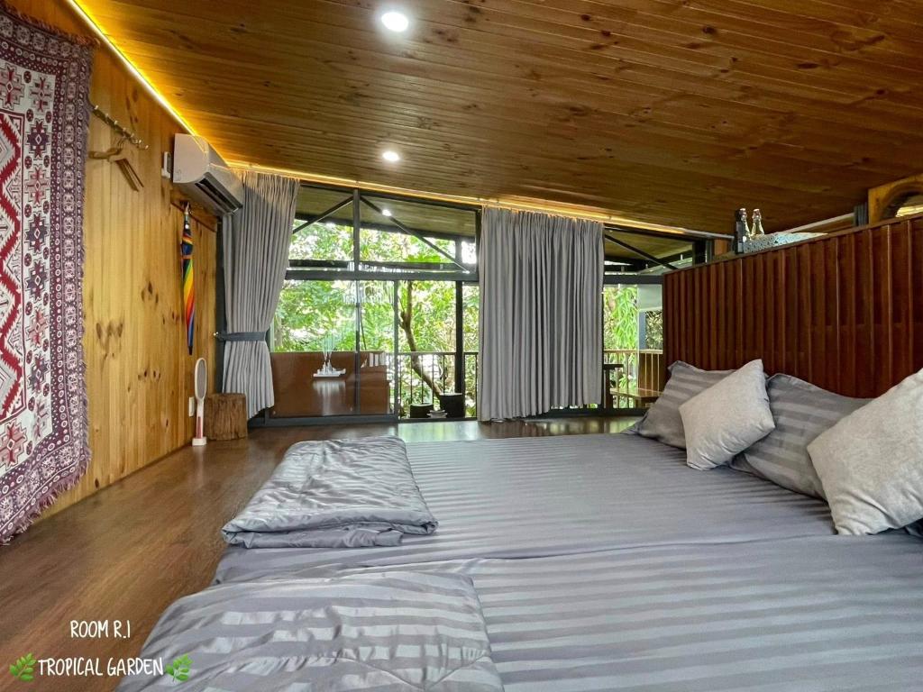 ein großes Bett in einem Zimmer mit Holzdecke in der Unterkunft TROPICAL GARDEN Homestay in Buôn Alê (1)