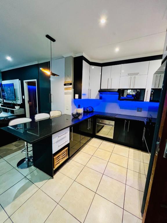 a kitchen with a large black counter and blue cabinets at The Wired Nest in Ellisras