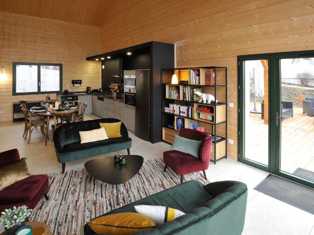 un salon avec un canapé et une salle à manger dans l'établissement Maison de campagne éco-construite, spa, proche Nancy, tout confort, petit-déjeuner inclus - FR-1-584-83, à Voinémont