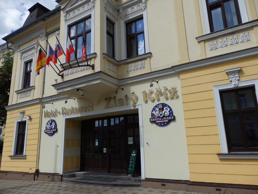 um edifício com bandeiras em cima em Hotel Zlatý Kříž em Teplice