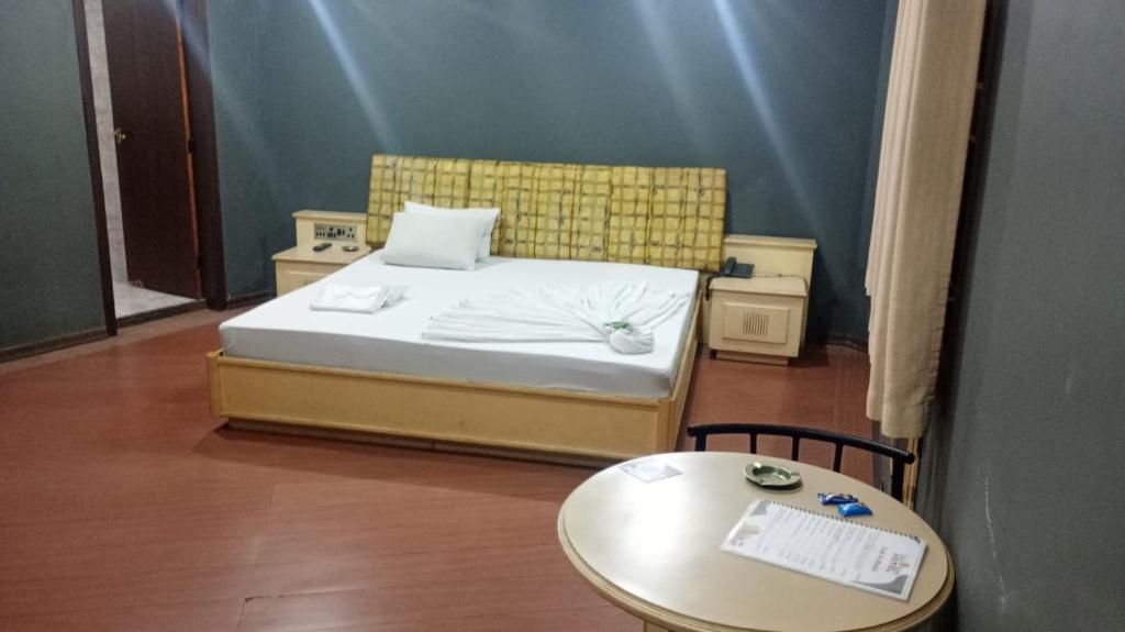 een kleine slaapkamer met een bed en een tafel bij Hotel Porto Calem in Sao Paulo