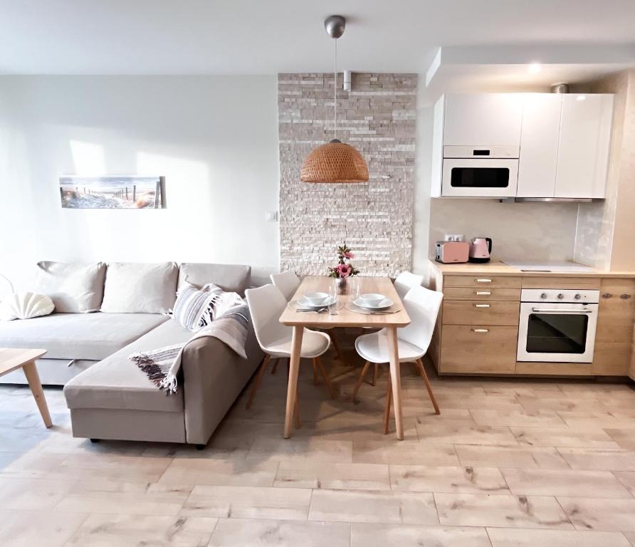 un salon avec un canapé et une table dans l'établissement Shells & Pearls Rewal - Wakacyjny apartament blisko morza, à Rewal