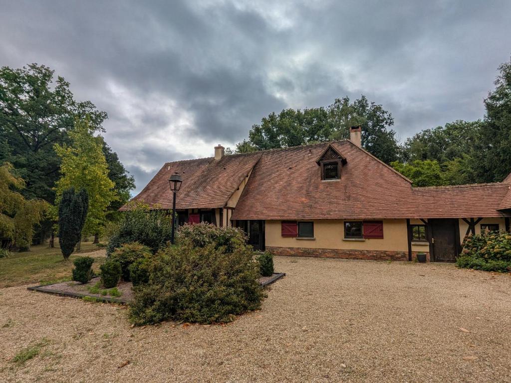 une maison dotée d'un toit rayé dans une cour dans l'établissement Maison isolée avec parc, étang privé et à 20 min du Zoo de Beauval - FR-1-591-309, à Vicq-sur-Nahon