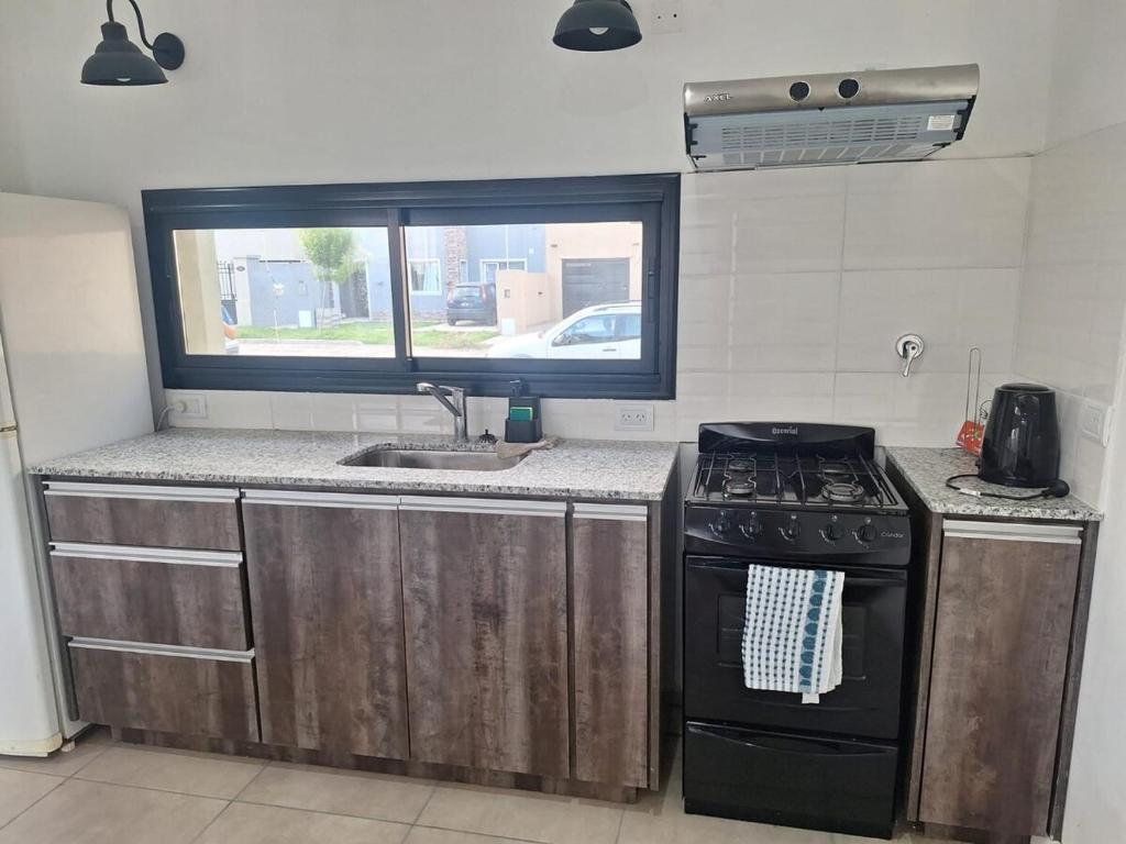 a kitchen with a stove and a sink and a window at Casa Clara in Tandil