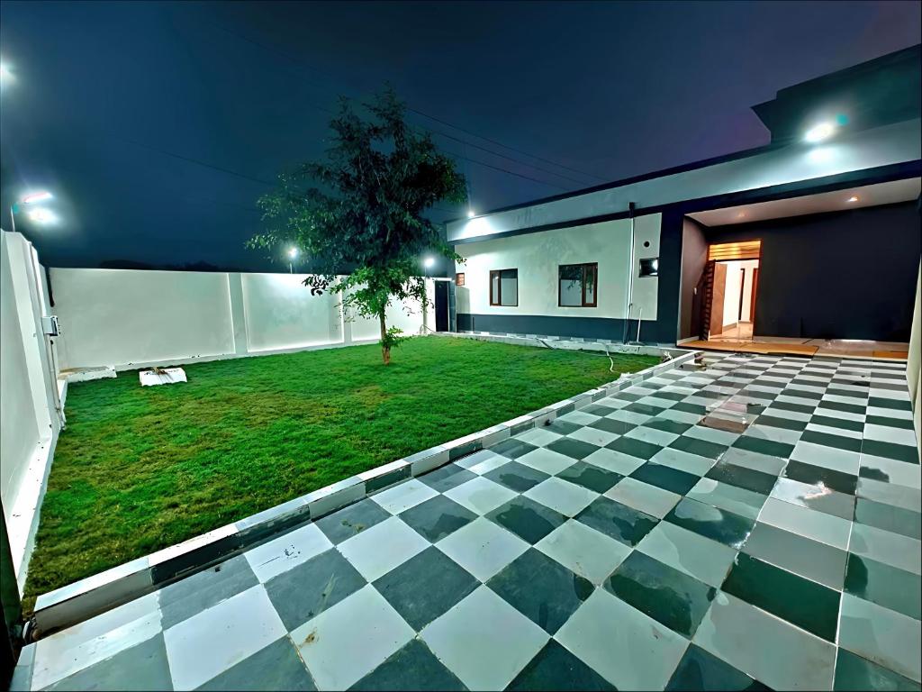 ein Haus mit Schachbrettboden und einem Hof in der Unterkunft A2 Vista - 4BHK Villa with Lawn Near Expo Mart in Greater Noida