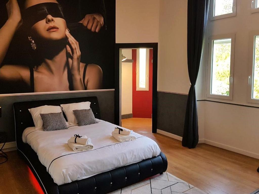 a bedroom with a bed with a poster of a woman at Suite Familiale au Château avec Balcon sur Parc - FR-1-591-767 in Cluis