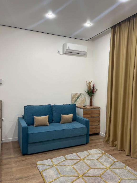 eine blaue Couch im Wohnzimmer in der Unterkunft Kolsay in Kirovo