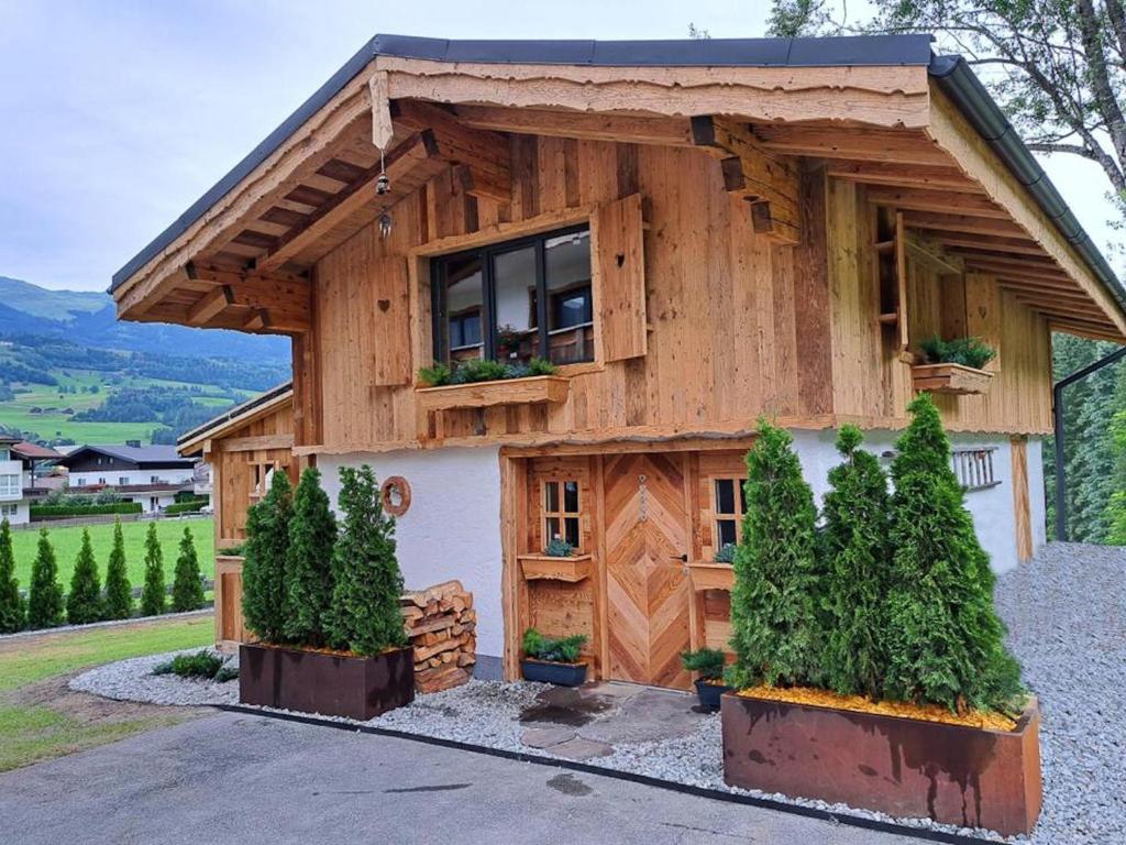una casa de madera con una ventana y algunos árboles en Almversteck Hollersbach, en Hollersbach im Pinzgau