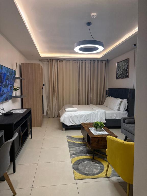 a hotel room with a bed and a couch and a table at Executive studio at East Legon in Accra