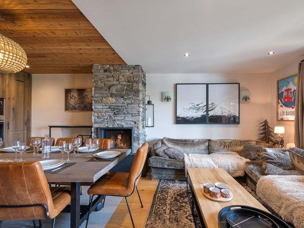 a living room with a table and a fireplace at Appartement avec Sauna et Jacuzzi aux Saisies - FR-1-809-14 in Les Saisies