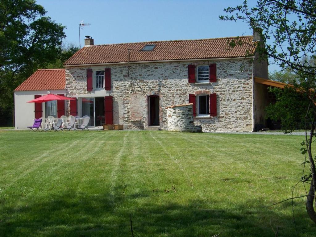 a stone house with a lawn in front of it at Maison rénovée en pleine campagne avec terrain, terrasse et équipements familiaux - FR-1-426-157 in La Roche-sur-Yon