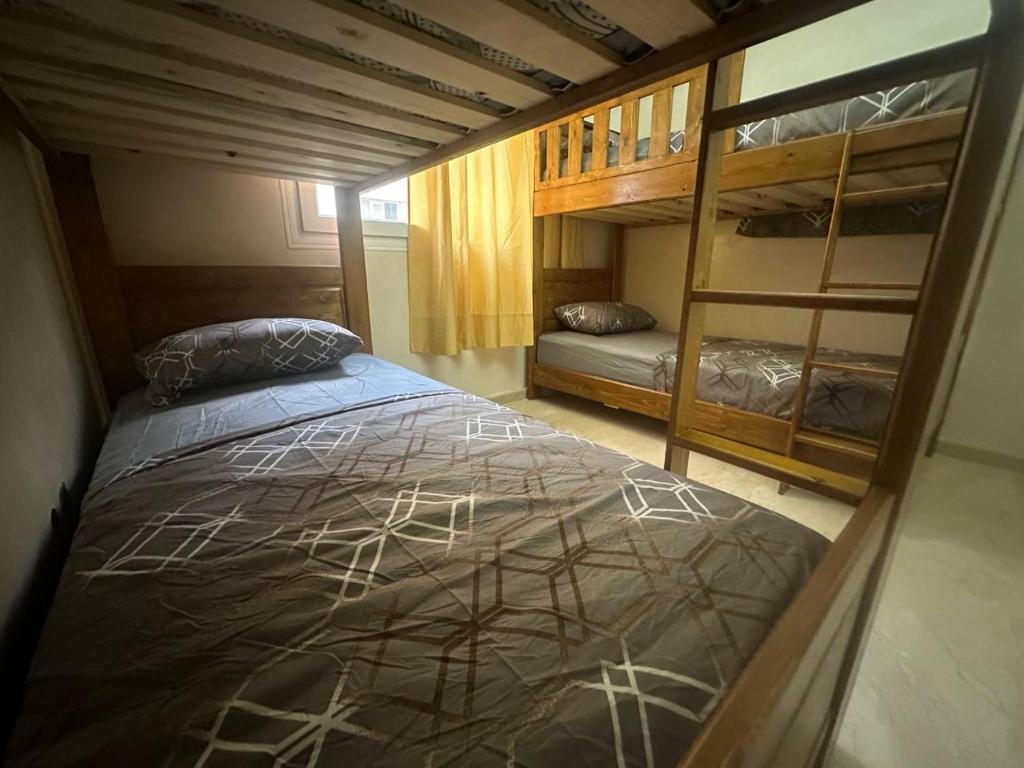 a bedroom with a bed and bunk beds at Abu Issa Hostel Tangier in Tangier