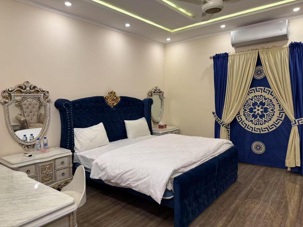 ein Schlafzimmer mit einem blauen Bett und einem Spiegel in der Unterkunft Aolai hotel in Islamabad