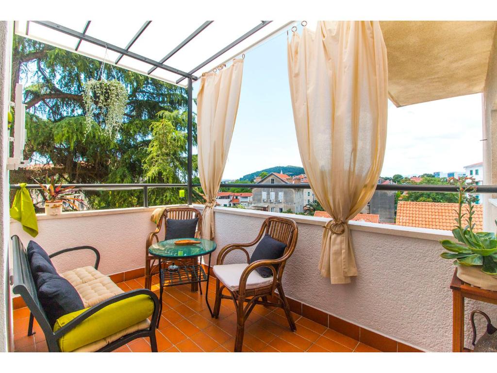 a balcony with chairs and a table and a window at Boutique City Center View Apartments in Split