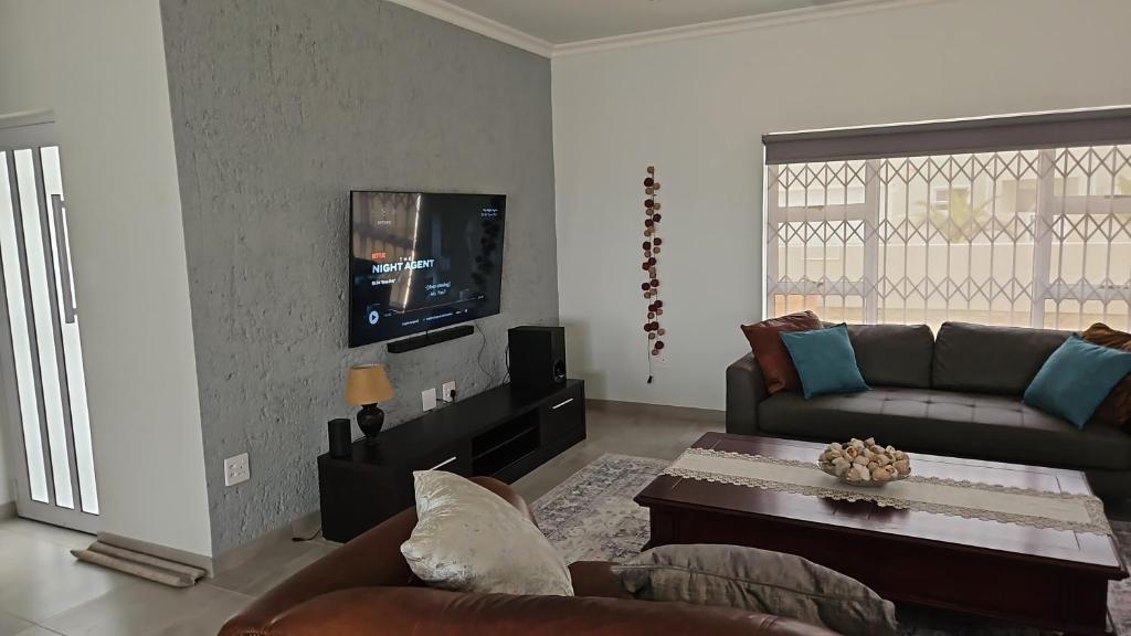 a living room with a couch and a tv at Atlantis in Hentiesbaai