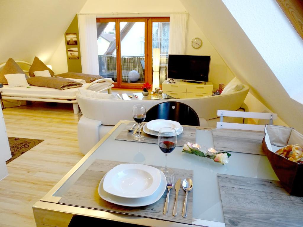 ein Wohnzimmer mit einem Tisch und Gläsern Wein in der Unterkunft Seeperle 1 in Meersburg