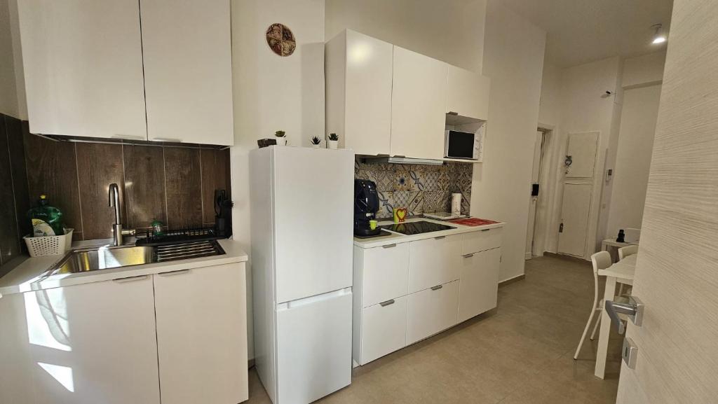 een keuken met witte kasten en een witte koelkast bij PETER PAN apartment in Salerno