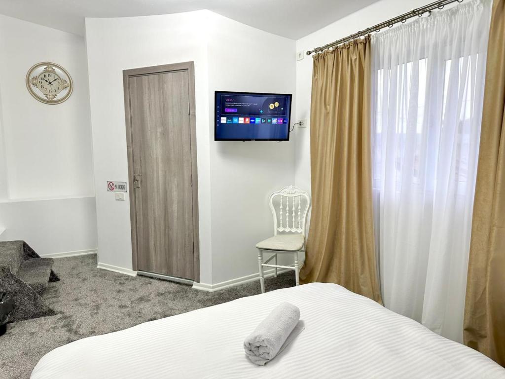 a bedroom with a bed and a television on the wall at Le Charme Hostel in Bucharest
