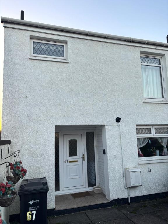 a white house with a white door and windows at OakHouse- Entire 3 Bedroom Terrace House with Free Parking in Cumbernauld