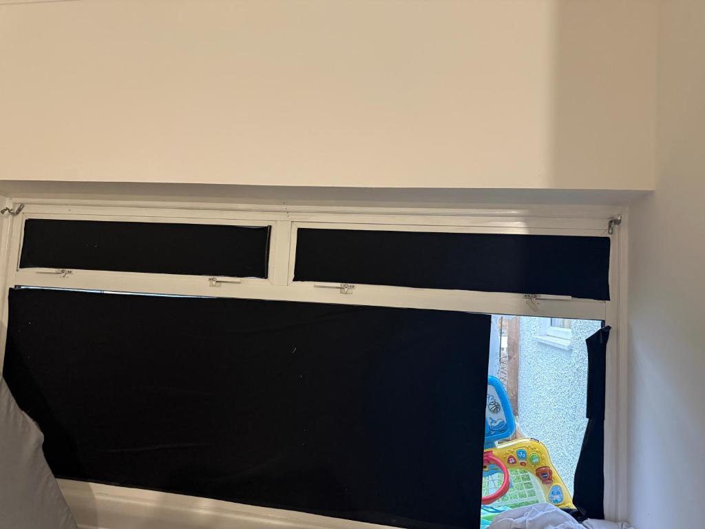 a window in a room with a curtain at Belin Stay in Hackbridge