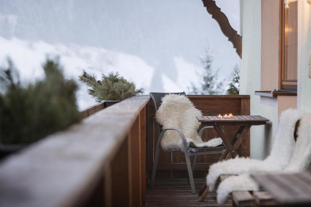 un perro sentado en una silla en un balcón en Haus Alpenkönig Stubai Gletscher Lodge, en Neustift im Stubaital
