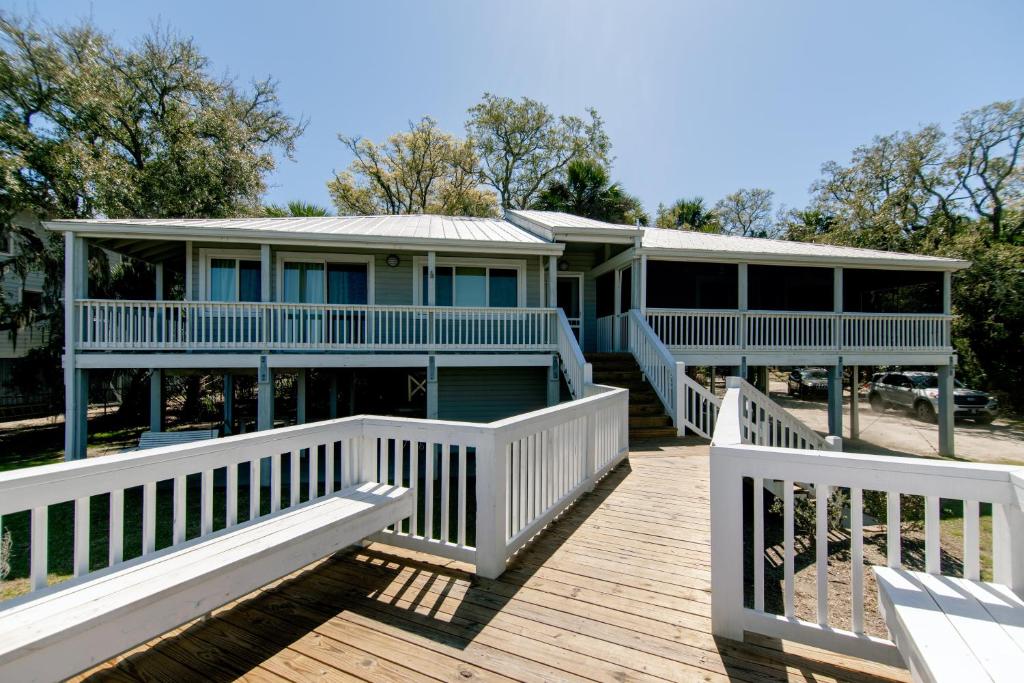ein Haus auf einer Holzterrasse mit zwei Bänken in der Unterkunft Shrimpers Cove in Edisto Island