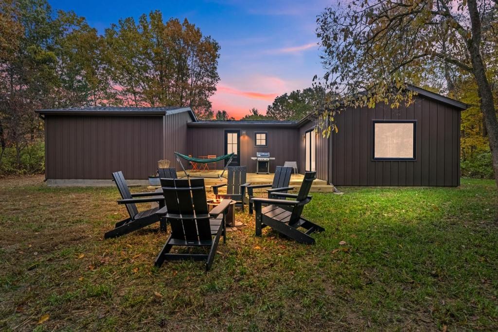 een achtertuin met een tafel en stoelen en een huis bij The Woodsmen in Douglas